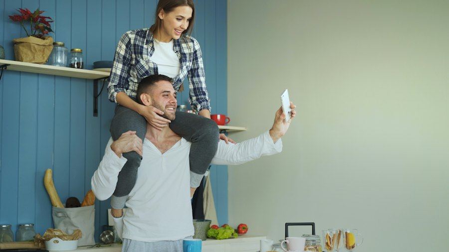 Couple laughing while taking a selfie in the kitchen