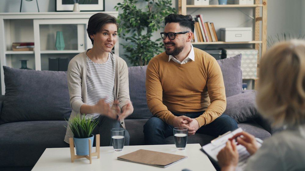 Counselor talking with clients on a couch