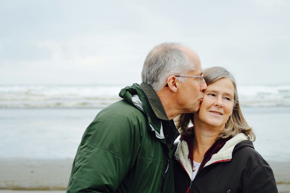 Older couple smiling together by the sea