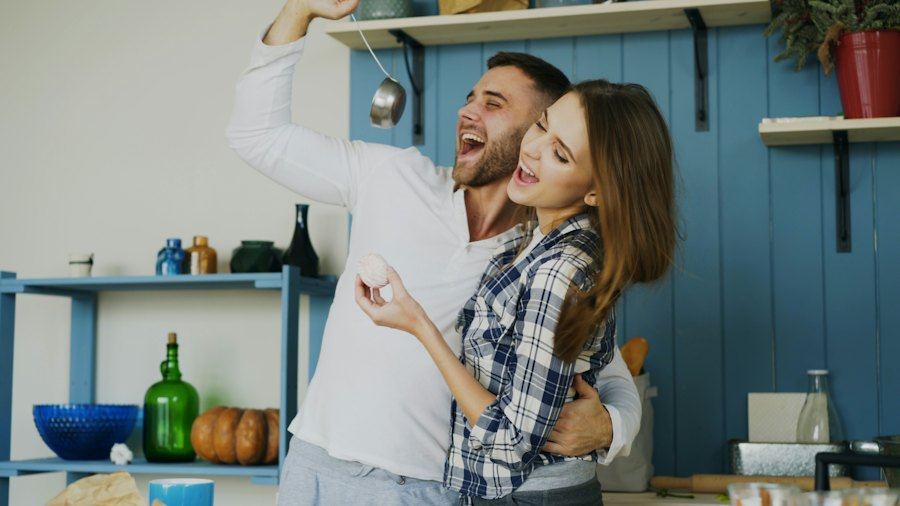 Couple dancing and singing in the kitchen
